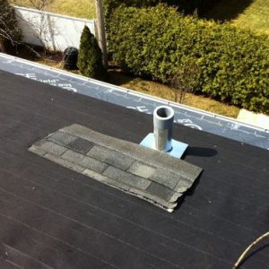 A roof with a black shingle on it